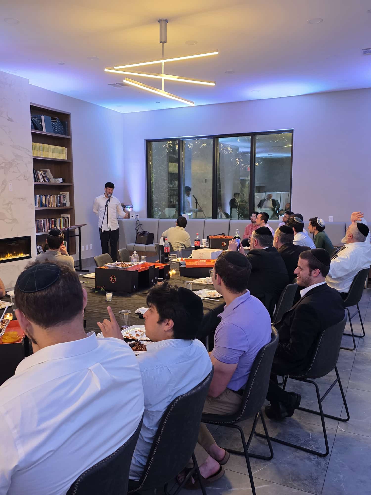 A speaker addressing students at an evening summer event