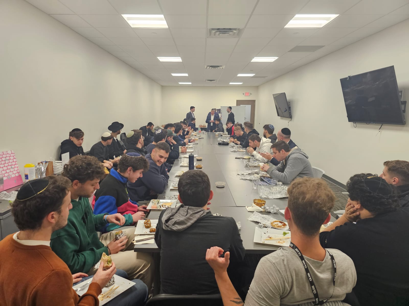 Long conference table of students sharing lunch during Fellowship learning