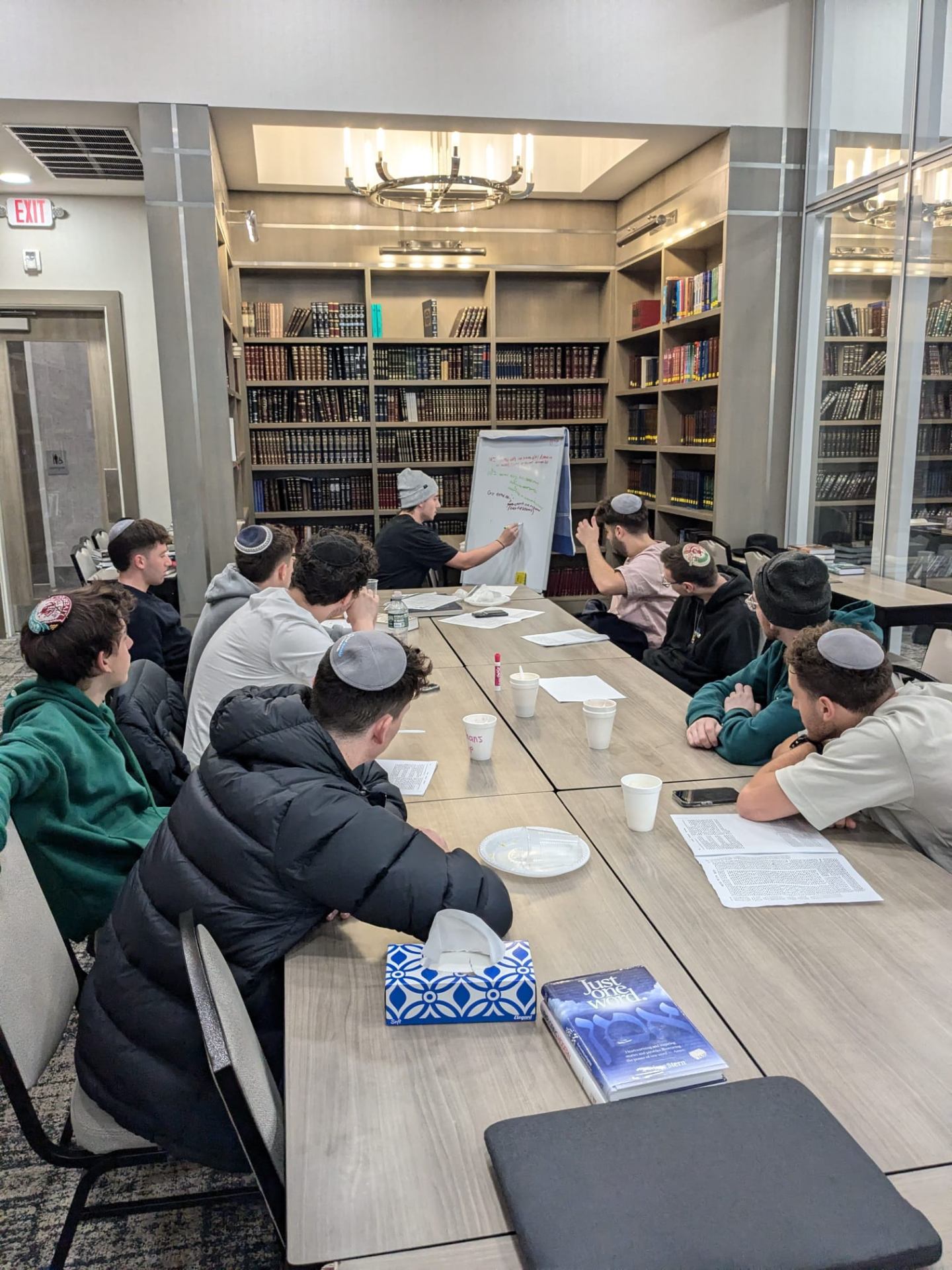 Students gathered around a whiteboard chavrusa in the beis medrash