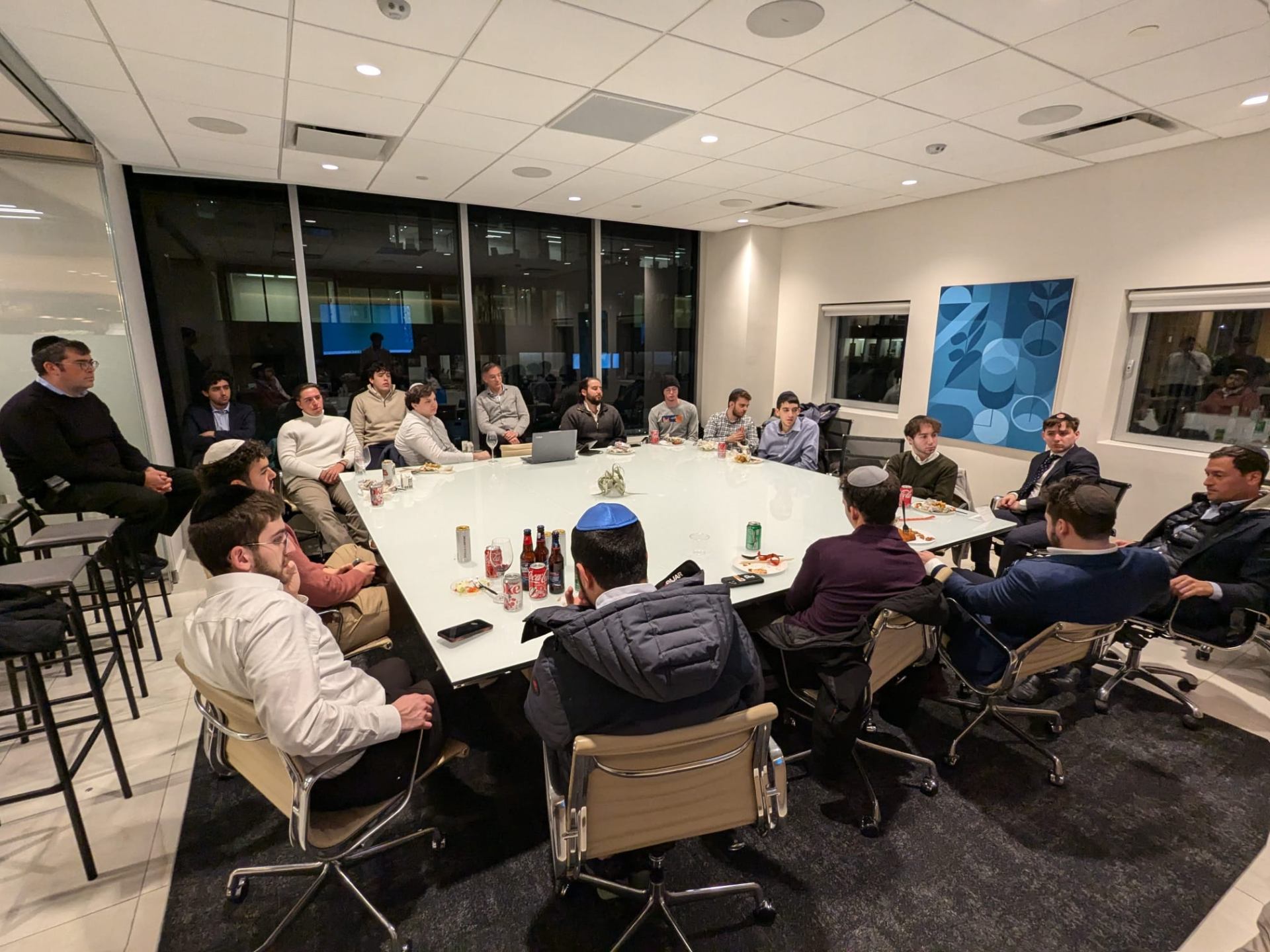A large group of students learning together in a corporate boardroom