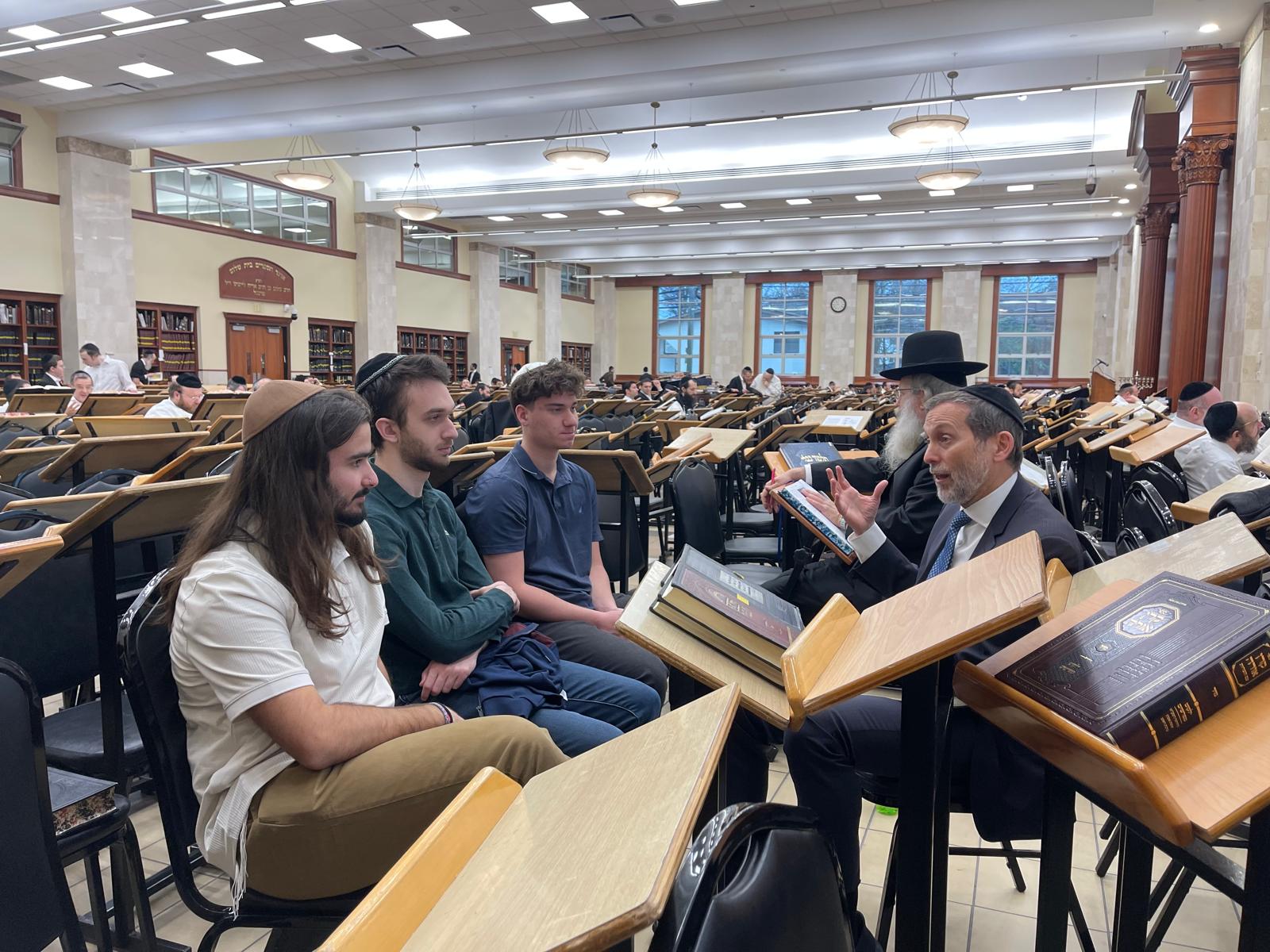 Students learning with rabbis in the main Lakewood beis medrash