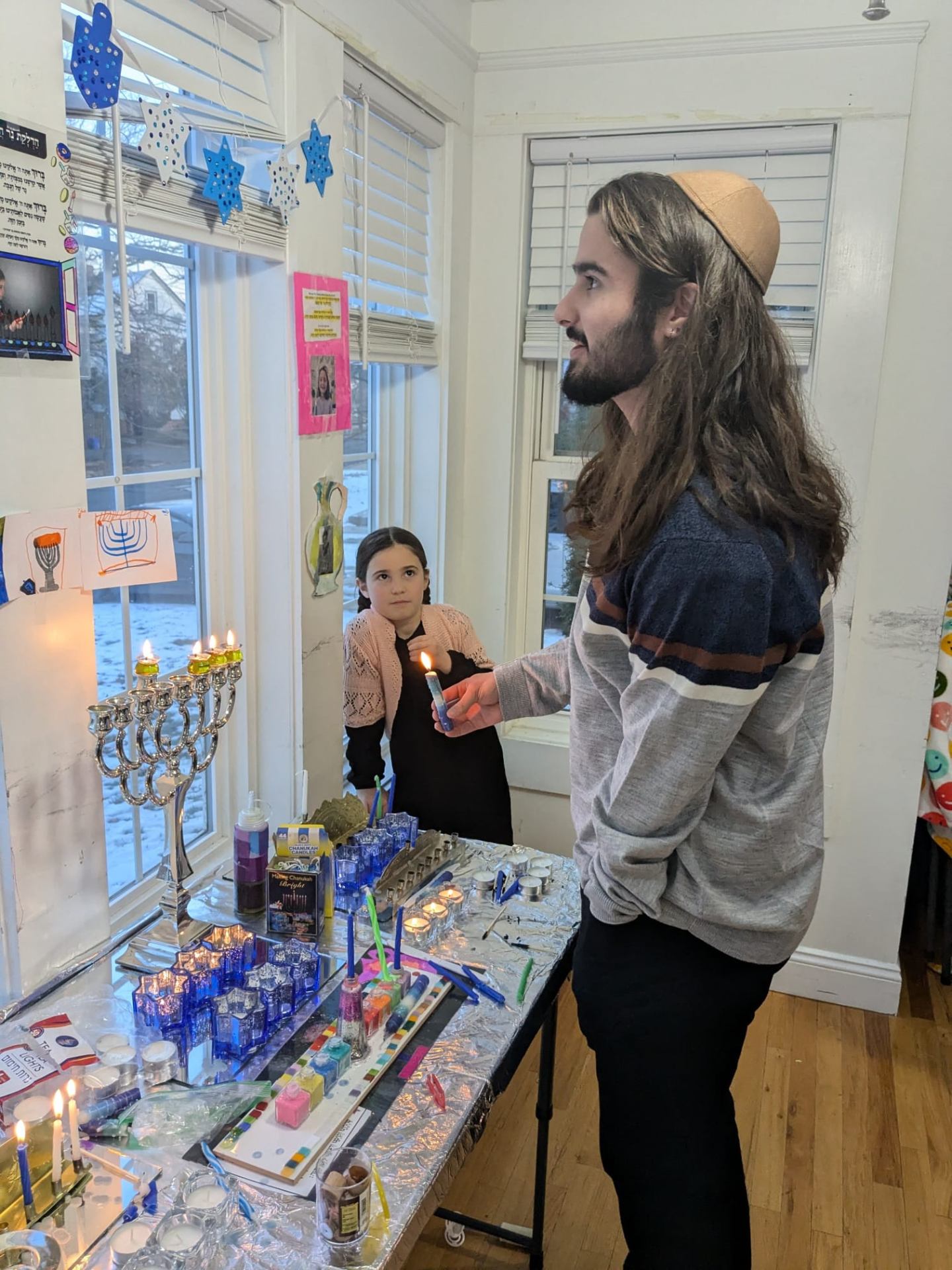 A student lighting the menorah on Chanukah